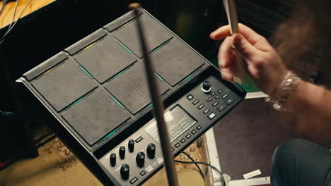 drummer plays an electronic drum kit in a music studio, recording music with sound engineer in rehearsal room. lesson of playing percussion drum instruments. rock music concert.