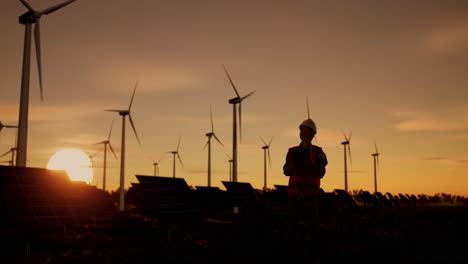 ingeniero en una granja eólica y solar al atardecer