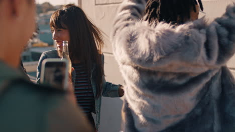 slow-motion-group-of-multiracial-friends-hanging-out-young-african-american-woman-dancing-enjoying-rooftop-party-at-sunset-drinking-alcohol-having-fun-on-weekend-celebration