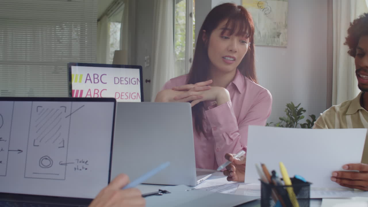 Diverse Coworkers Discussing App Design at Office Desk