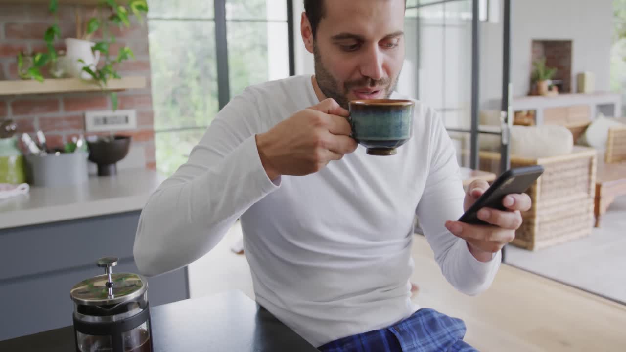 hombre bebiendo café y usando teléfono móvil en la mesa de comedor en un cómodo 4k