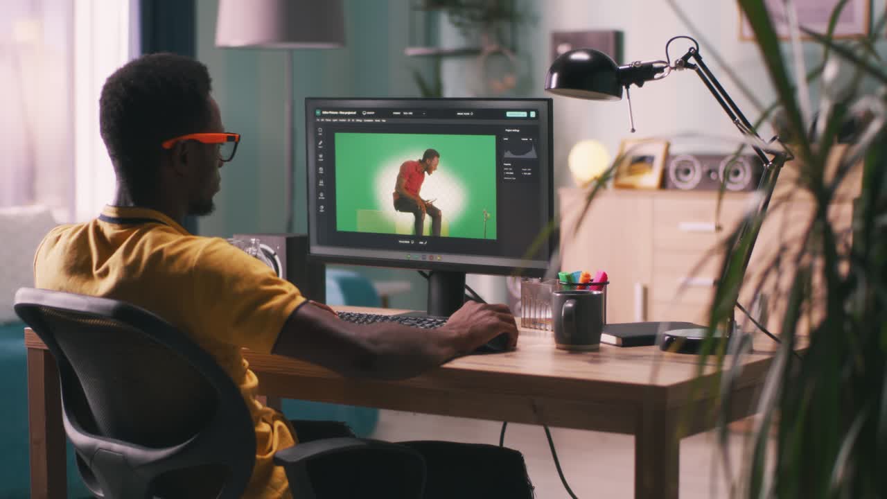hombre afroamericano editando video con fondo chromakey
