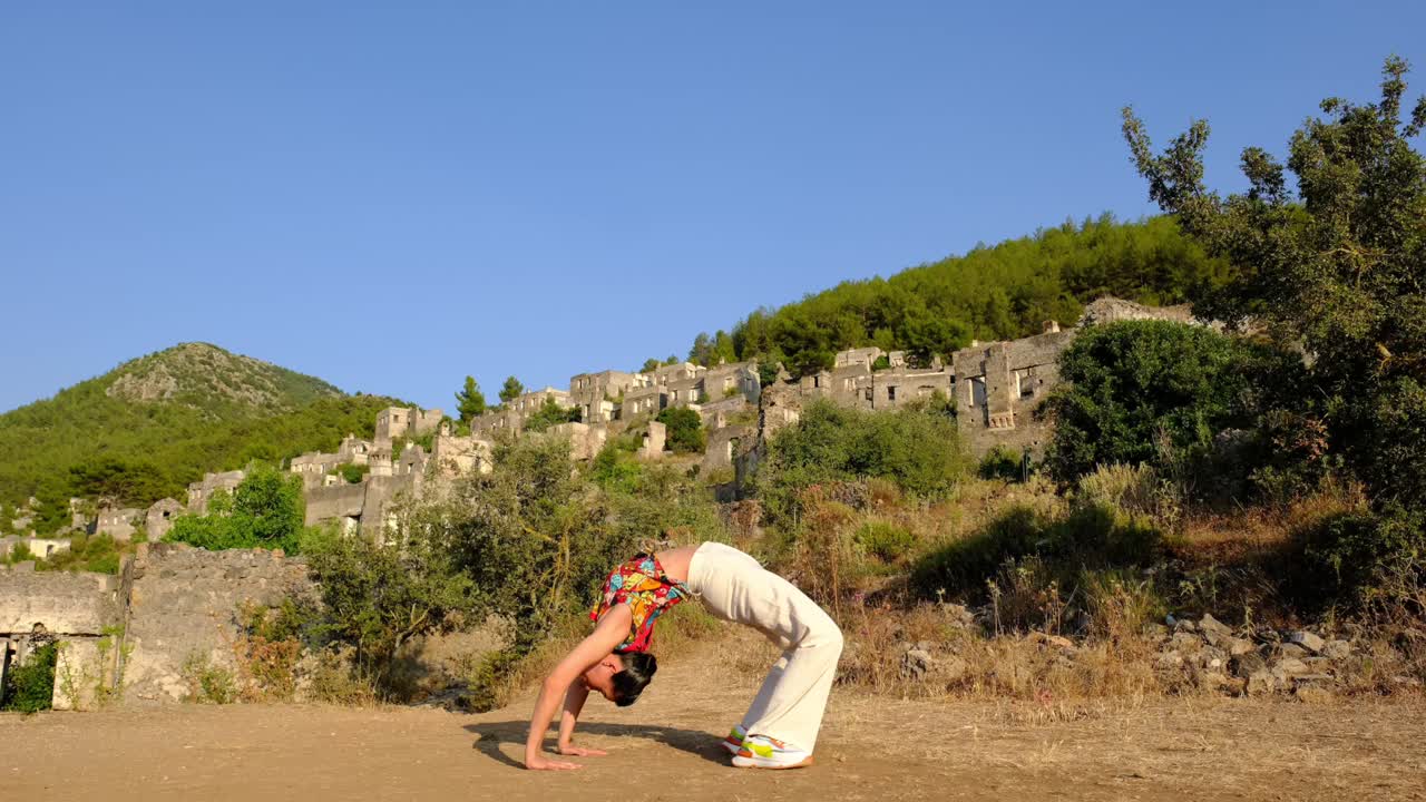 una mujer hace yoga y se estira en un espacio natural