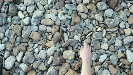 male hand taking and throwing pebble stones