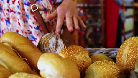 Mid-section-of-woman-selecting-bread