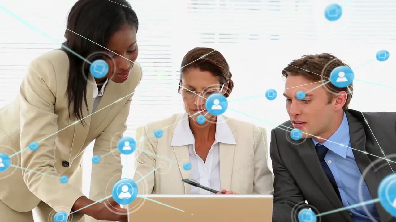 Animation of network of digital icons against diverse colleagues discussing over a laptop at office