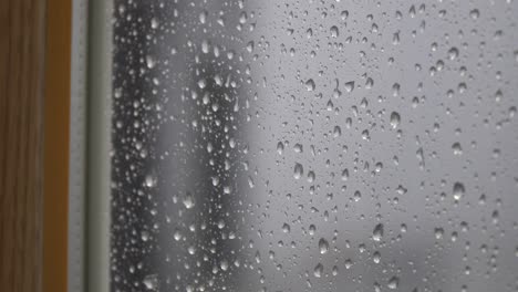 gotas de lluvia goteando en el exterior de la ventana borrosa - cerrar