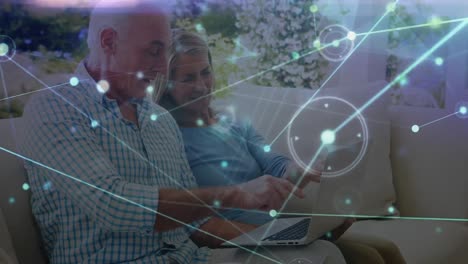 animation of network of connections with light trails over senior caucasian couple using laptop