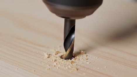 a drill bit functions skillfully as it penetrates the surface of a piece of wood, creating a perfect hole. this technique is essential for various woodworking and diy applications.
