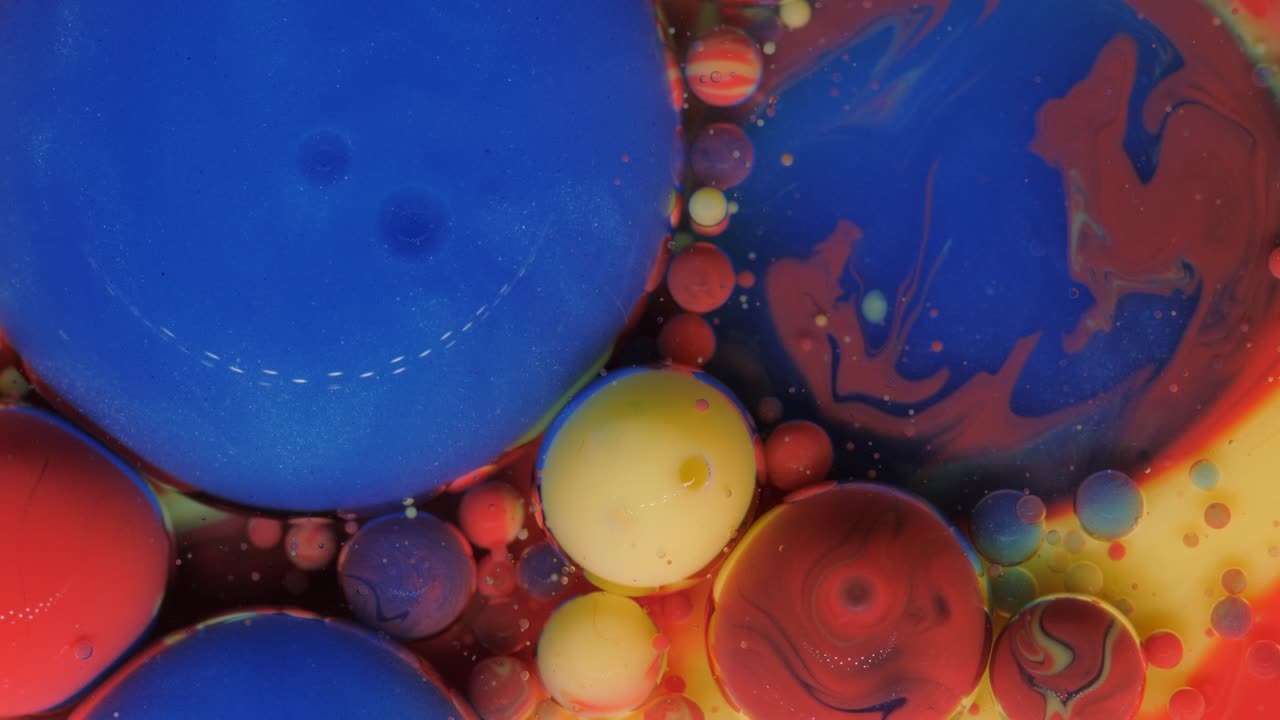 burbujas rojas, azules y amarillo-doradas sobre un fondo rojo.