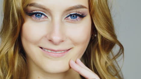 portrait of a young blue-eyed woman relates her face fingers hd video