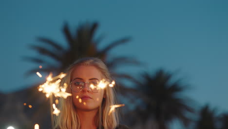 woman-holding-sparklers-celebrating-new-years-eve-at-sunset-enjoying-independence-day-celebration-4th-of-july