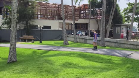 mujer patinando en un parque tropical