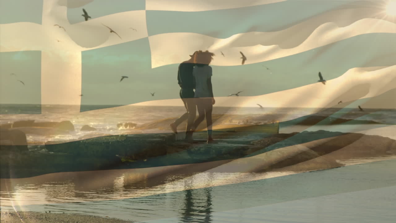 Animation of waving greece flag against african american couple walking together at the beach