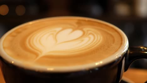 a beautiful cup of coffee with intricate latte art showcasing creamy texture and aroma, perfectly brewed for coffee lovers in a warm cafe environment