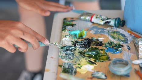 artist mixing paints on a palette