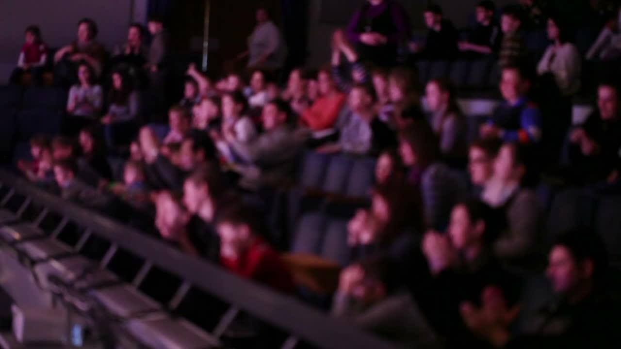 Persone sfocate applaudono a teatro