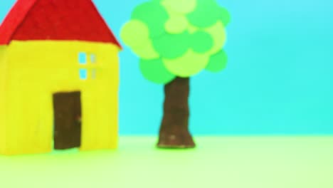 orange car passing by yellow house and tree - stop motion