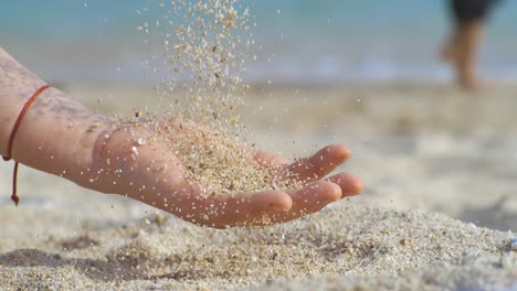 arena cayendo de la mano en cámara lenta en una playa. vacaciones y concepto de viaje. disparado en cámara súper cámara lenta 1000 fps.