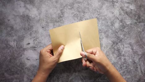 cutting brown paper with scissors