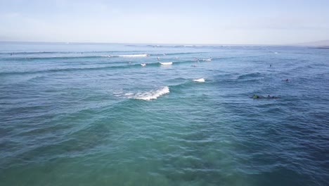 Olas-Rompiendo-Agresivamente-Sobre-Los-Surfistas-En-La-Playa-De-Waikiki-Honolulu-Hawaii,-Inclinación-Del-Carro-Aéreo-Hacia-Abajo