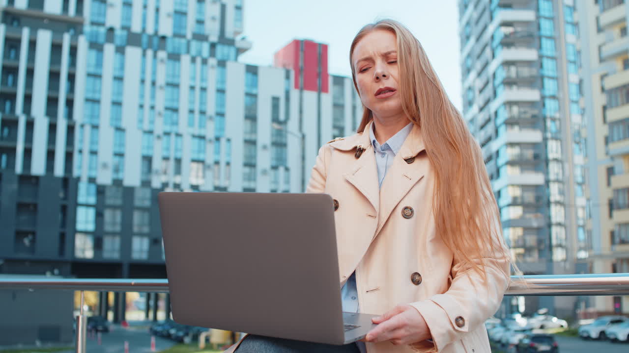 Mature caucasian woman on laptop in downtown street sees bad lottery results looking disappointed