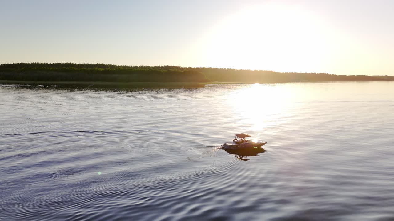 Cinematic drone shot of Motorboat on lake Calm Water during golder hour sunset
