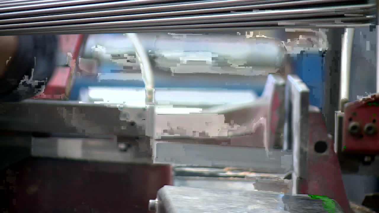 Worker Handling Metal Parts in a Manufacturing Environment