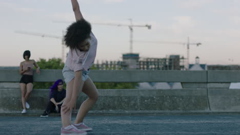 Mujer-Bailando-Atractiva-Joven-Bailarina-De-Raza-Mixta-Realizando-Baile-Callejero-De-Estilo-Urbano-En-La-Ciudad-Practicando-Movimientos-De-Estilo-Libre-Amigos-Viendo-Disfrutando-Pasar-El-Rato-Al-Atardecer