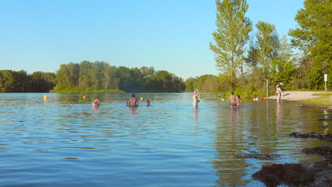 people swimming and relaxing in a lake on a sunny summer day