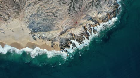 Aerial-view-above-a-4x4-truck-on-the-rocky-coast-of-Baja-California,-in-sunny-Mexico---cenital,-drone-shot