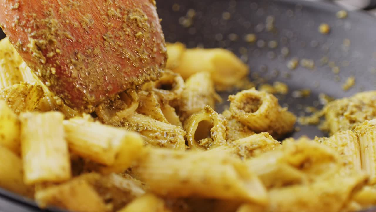 cocinar pasta de pesto con cuchara de madera