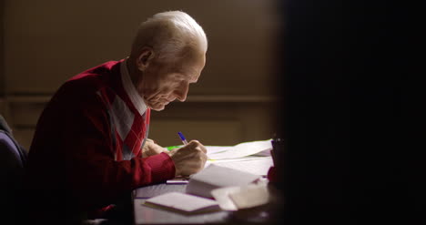 empresario senior escribiendo en papel en la mesa en la oficina