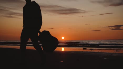 Man-running-with-guitar-in-back-sand-beach-at-sunset-15