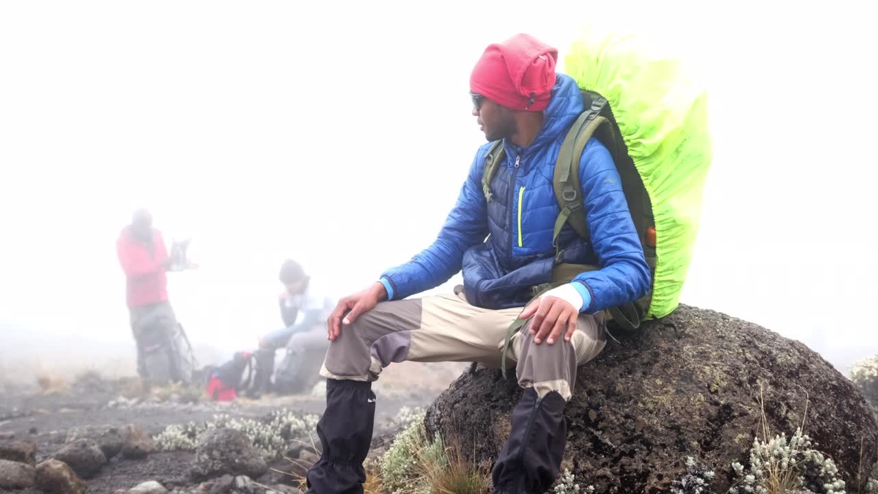 관광객은 산의 돌 위에 휴식을 취하고 있습니다.