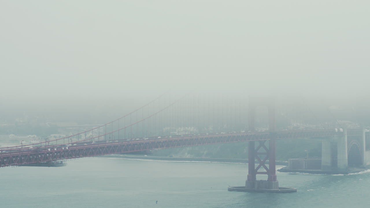 아침에 차량이 가로질러 갈 때 금문교의 안개가 자욱한 전망