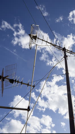 a timelapse of the sky and clouds with television aerials in the foreground