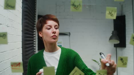 woman in office with coffee and post-it notes