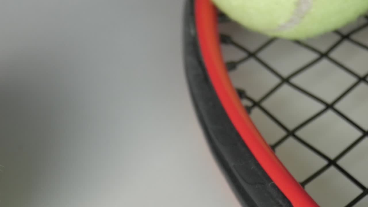 Close-up of tennis ball and racket, focusing on gear and sport activity