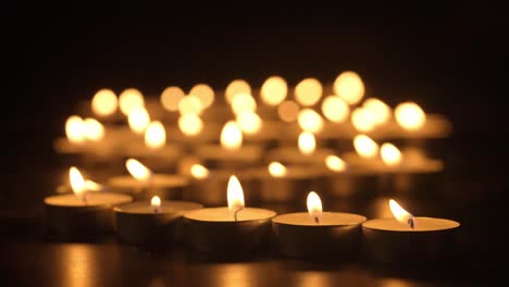 many tea light candles glowing in the dark