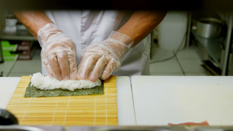 chef masculino preparando un rollo de arroz en la cocina 4k