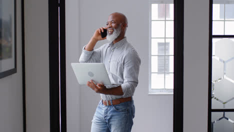 businessman talking on mobile phone while using laptop 4k