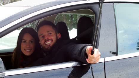 Pareja-Tomándose-Una-Selfie-En-El-Auto-En-Un-Día-Nevado