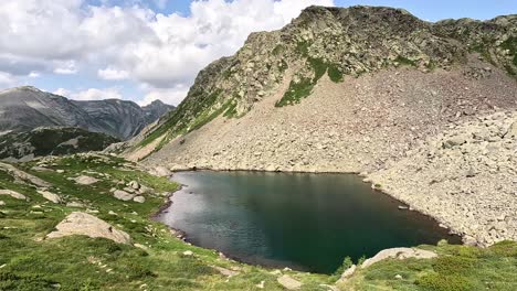 tschawinersee, an alpine lake located near the simplon pass in valais, switzerland, offers a serene view of clear waters surrounded by rugged mountains and verdant terrain.