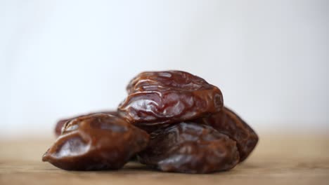 close up of dried date fall into pile, white background with copy space