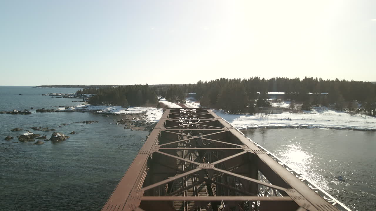 drone volando sobre un puente de tren sobre el océano en chandler, québec, canadá