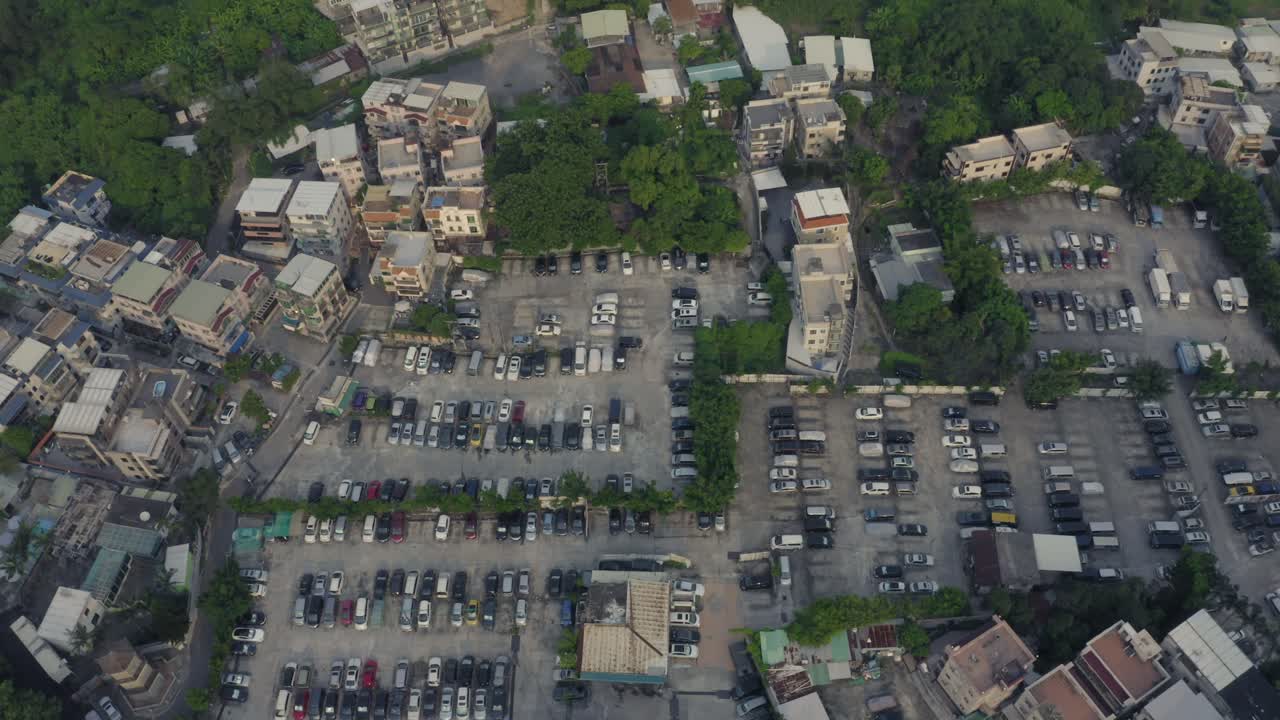 주변에 나무가 있는 도시 지역 중간에 큰 주차장이 있는 전형적인 중국 남부 마을