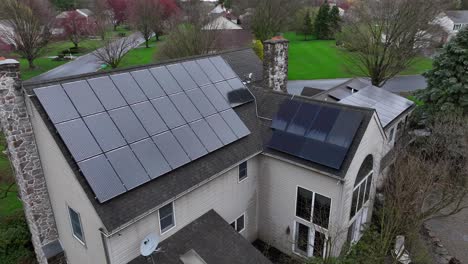 aerial approaching shot of old house with modern solar panels in roof