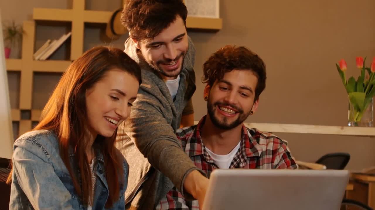 colegas discutiendo sobre la computadora portátil