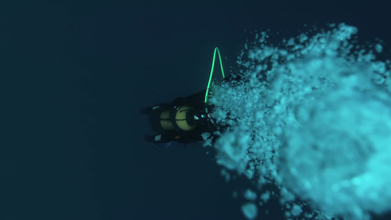 바다에서 거품이 떠다니는 수중 다이버는 열대 푸른 바다에서 표면으로 떠다닙니다.